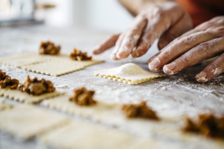 hands on a shef table making pasts