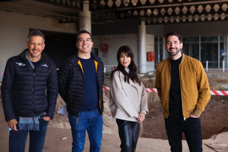 four people standing in a building site