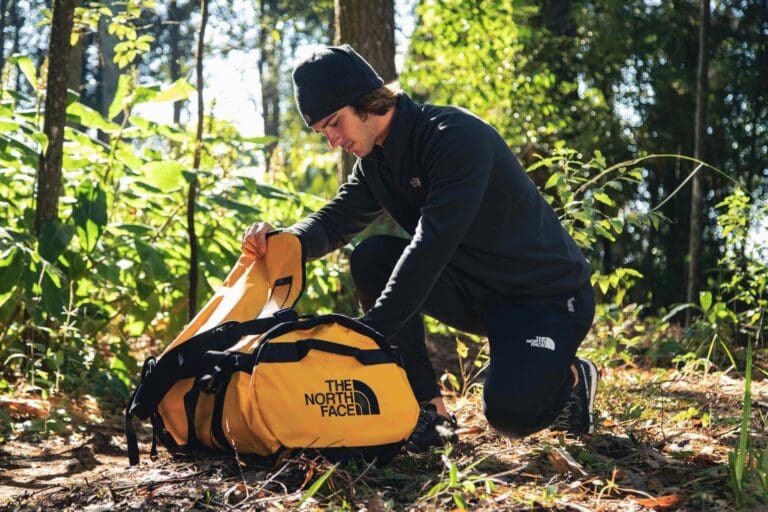 Man packing his bag on the trail