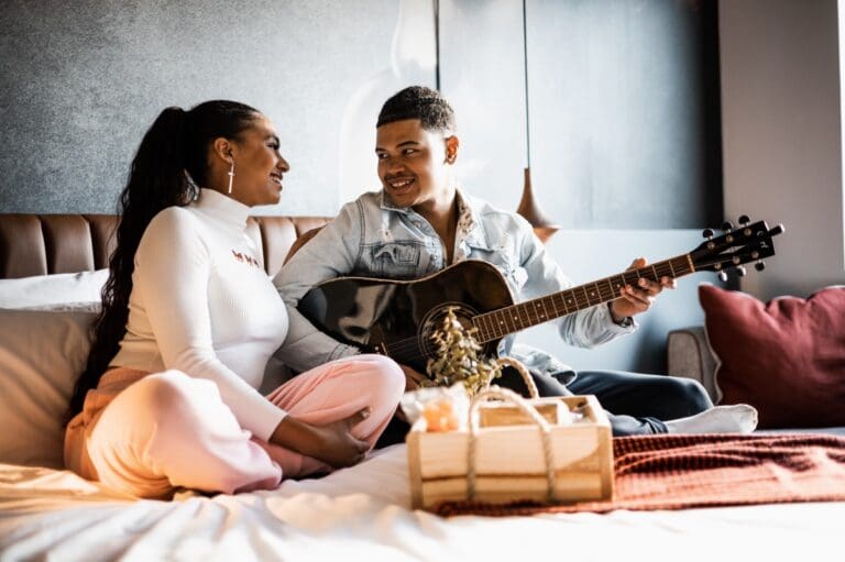 two people sitting on a hotel bed