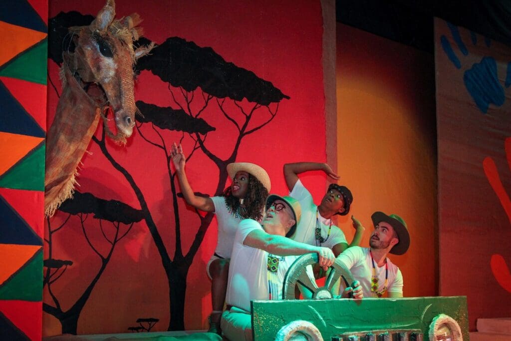 Group of actors on stage in a car