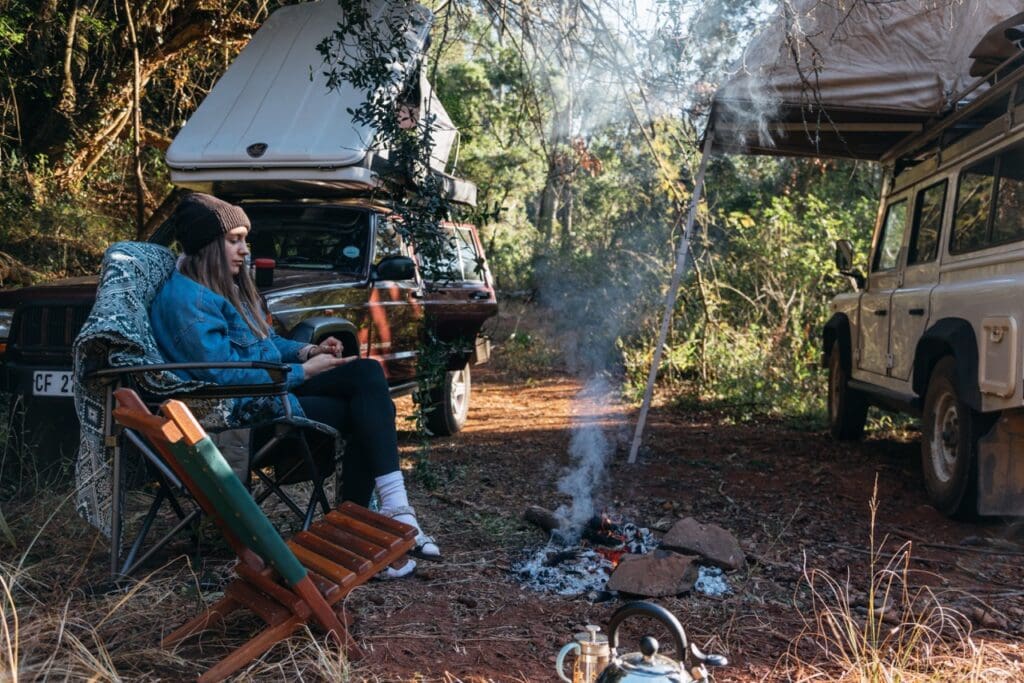 Lady sitting in front of a campfire