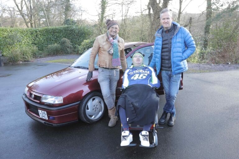 Fuzz Townshend, Darren Russell, and Tim Shaw posing next to the car with his family and friends. (National Geographic)