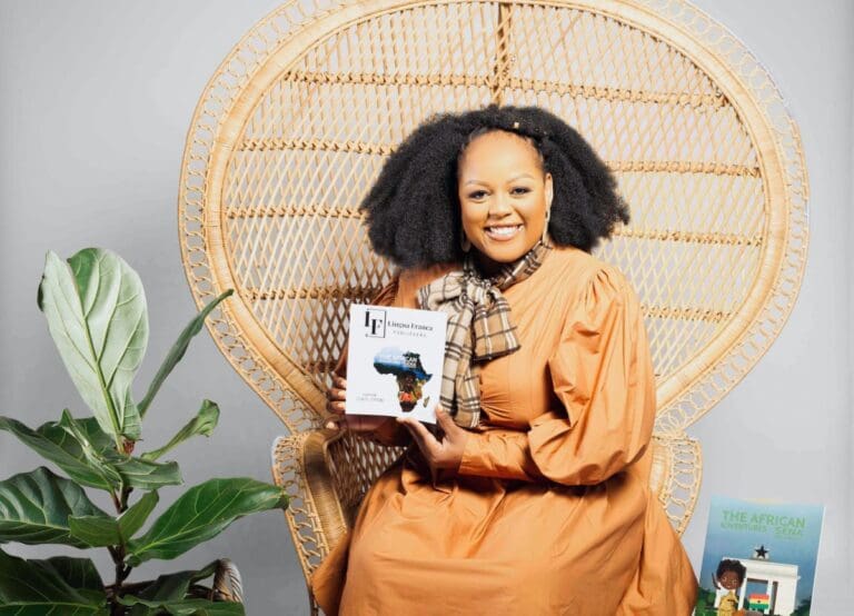 Carol Ofori sitting on a chair with her new books