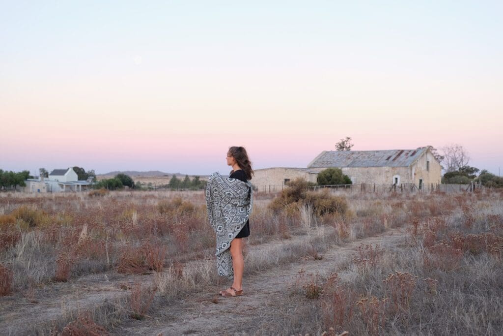 Girl standing in a field with cotton blanket on