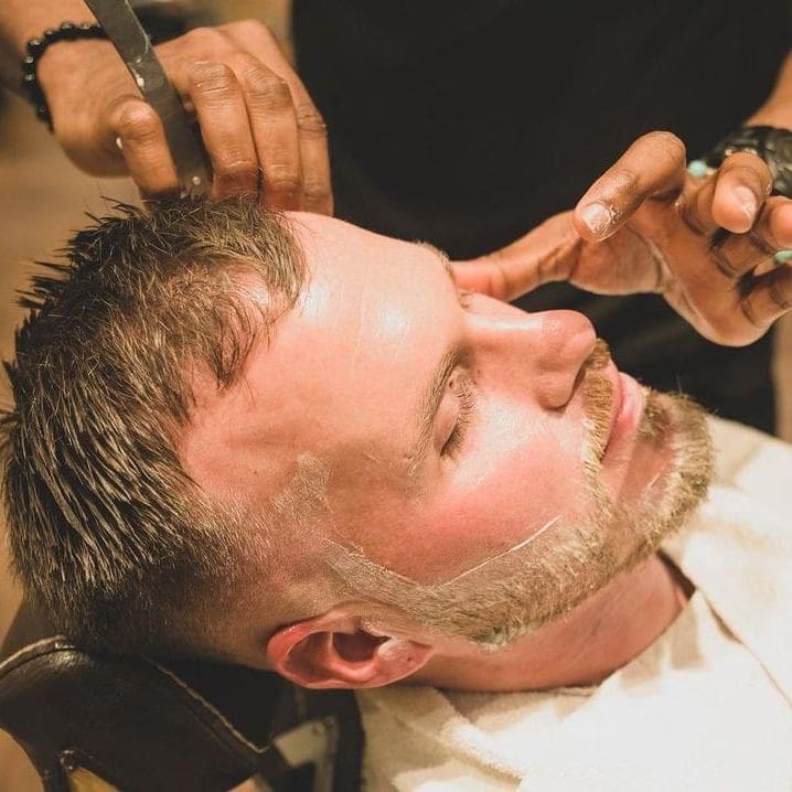 Man getting a shave in barber chair