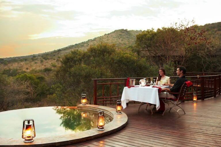 Couple sitting on a deck overlooking African bush