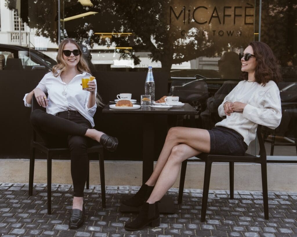 Two women sitting outside a coffee shop in Cape Town