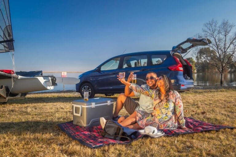 Two people next to a Suzuki