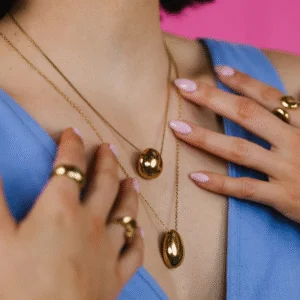 Women wearing gold plated jewellery including rings and necklaces.