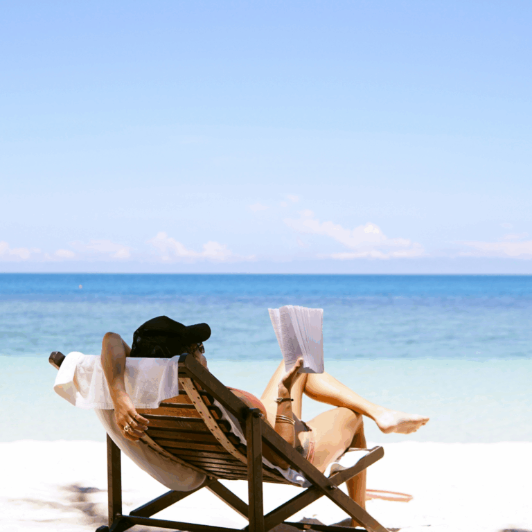 Person reading a book on the beach
