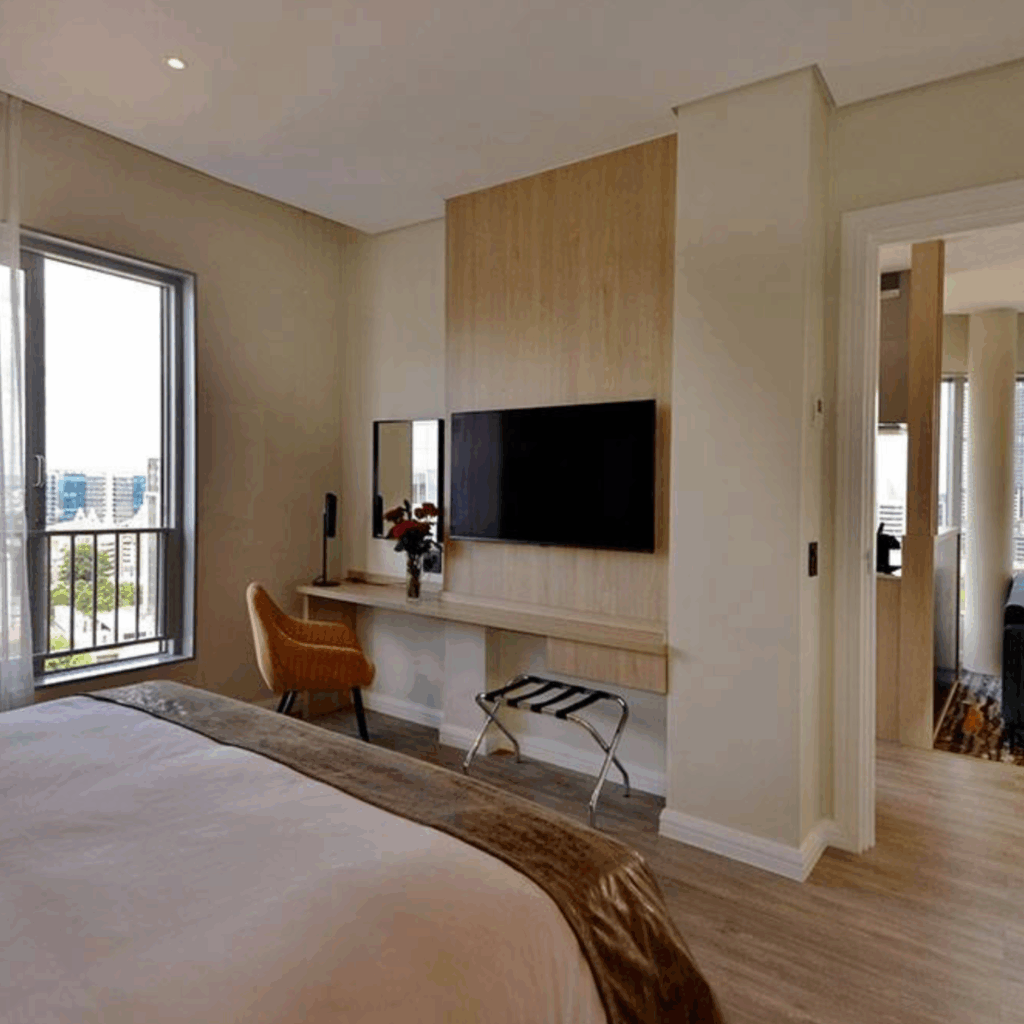 @Sandton Hotel Junior Suite Bedroom with desk and television and balcony
