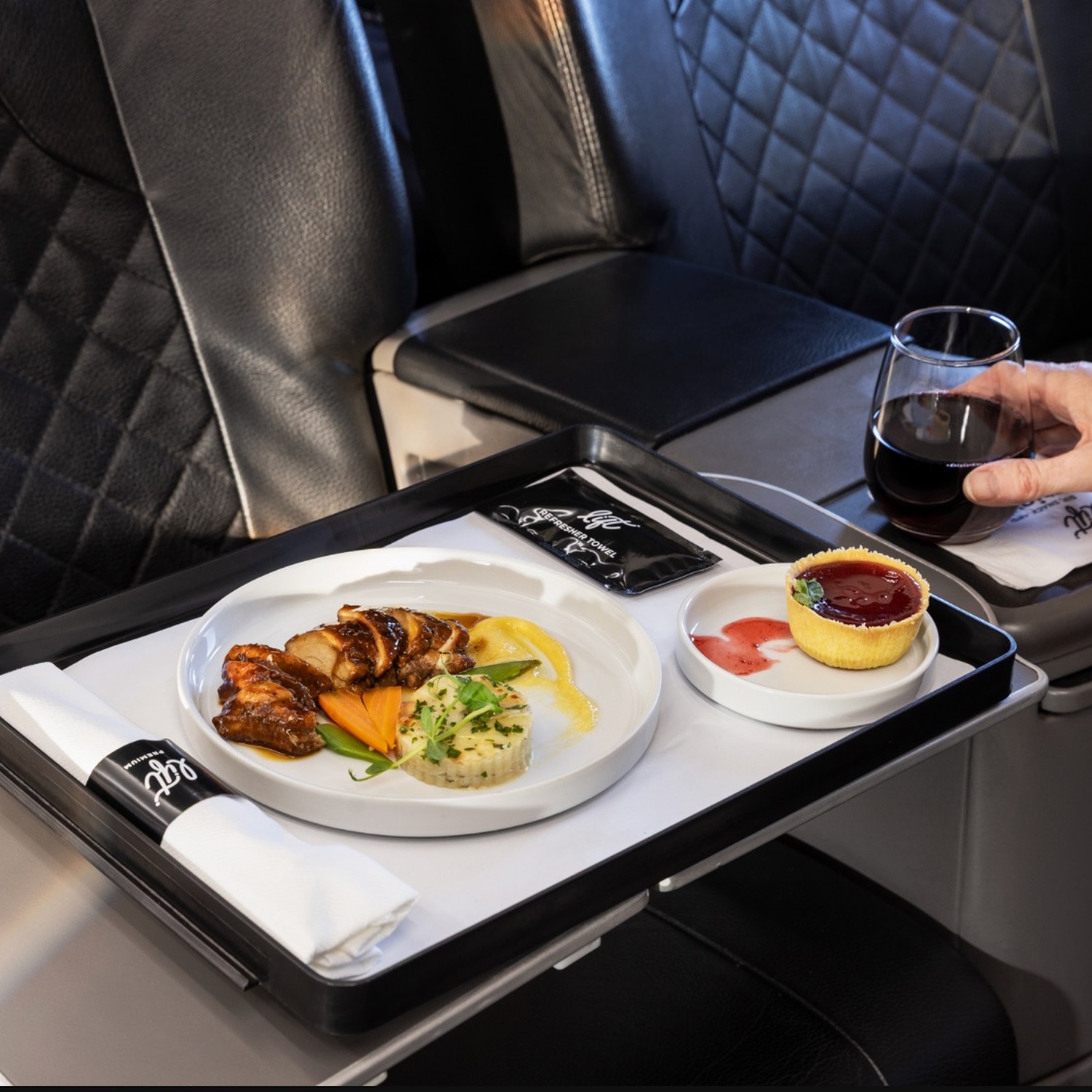 LIFT Premium meal and drink served on an aircraft tray table