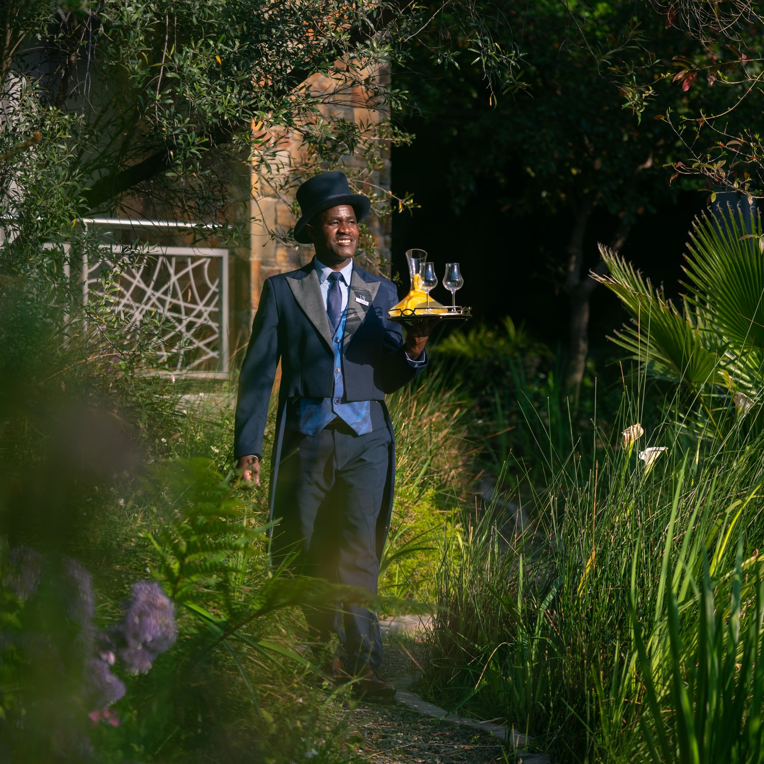 Hotel staff member beside a sculpture in the garden